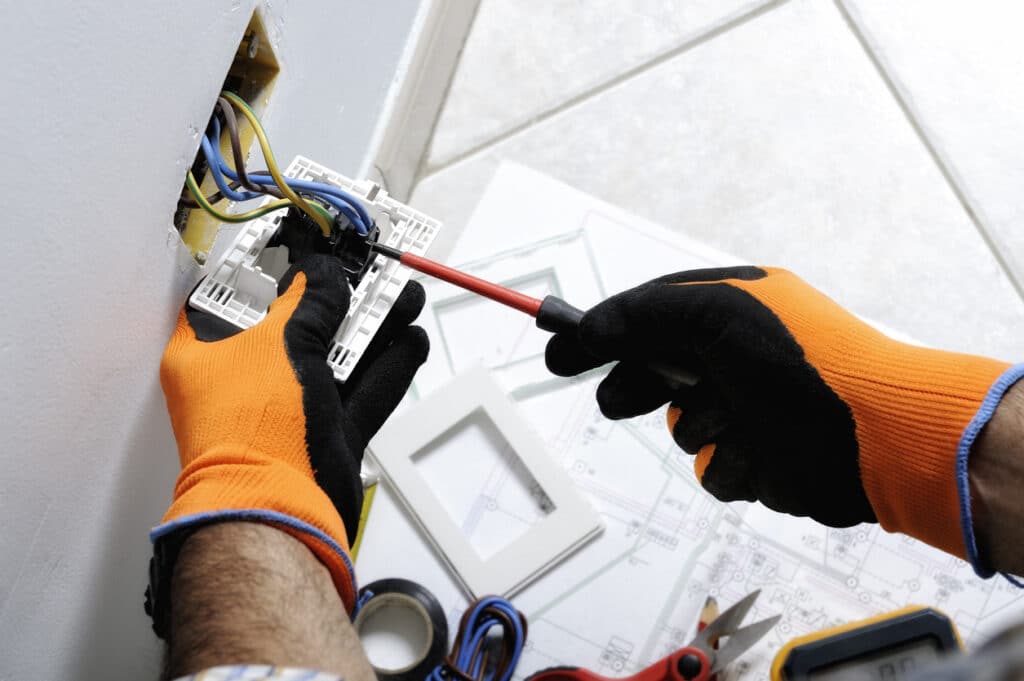 Electrician working safely on switches and sockets of a residential electrical system